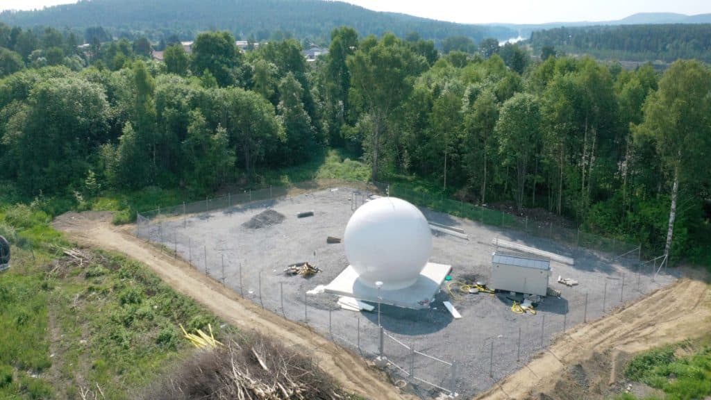 A white dome containing a dish that make its possible to communicate with satellites i space.