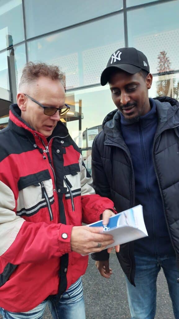 Axel och Omar tittar i broschyrer om Boden utanför Försvarsmuseum