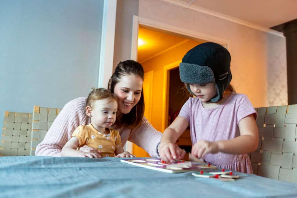 Mother with two children playing at a table