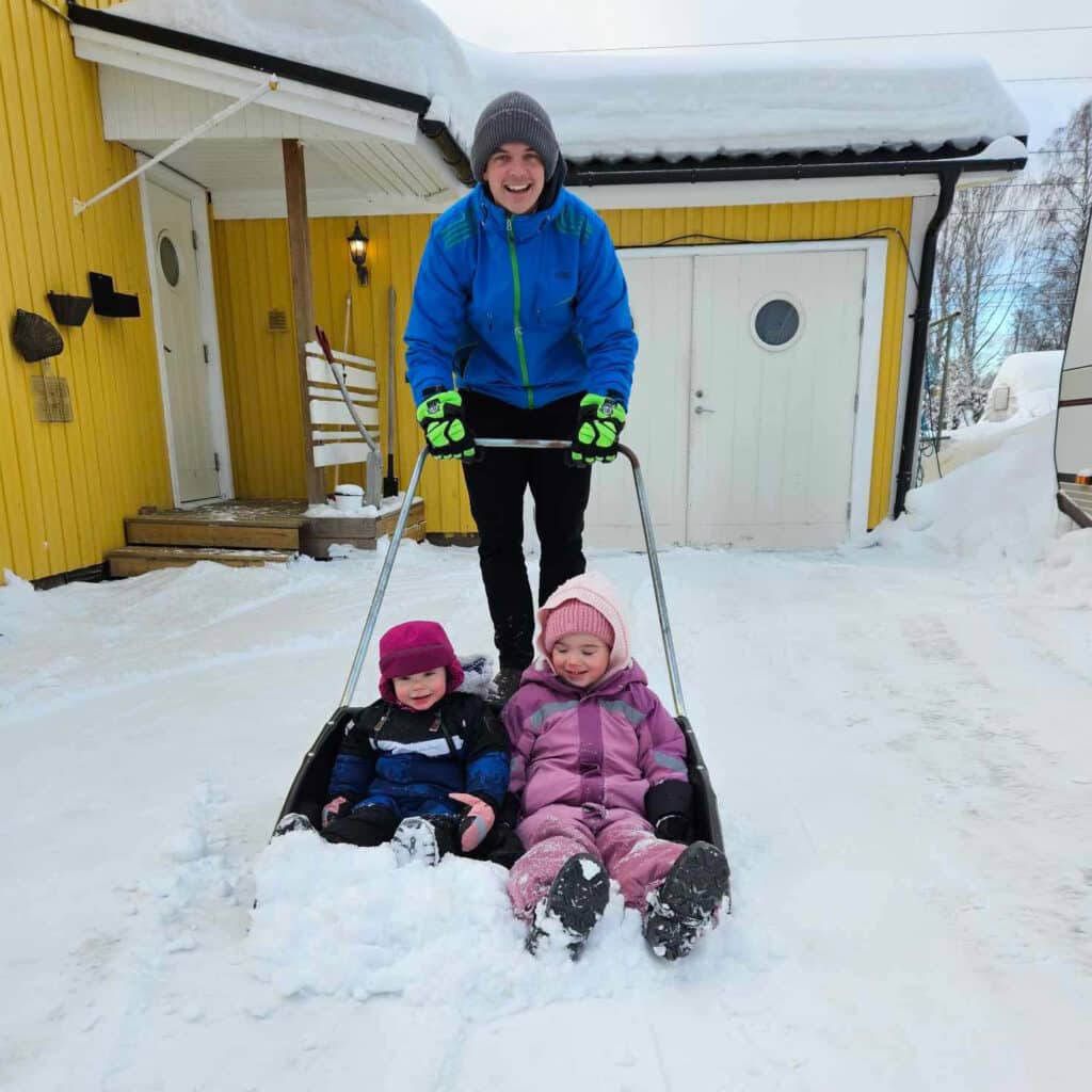 Father with two children shoveling snow