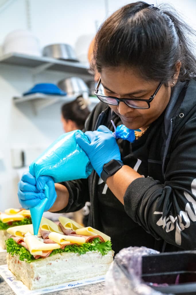 Naveena decorates a sandwich cake
